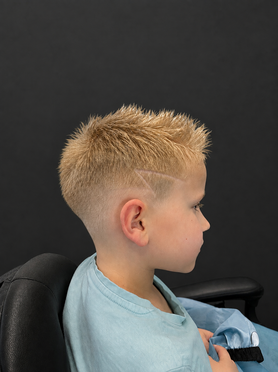 Blonder Kinderhaarschnitt mit Fade und Design